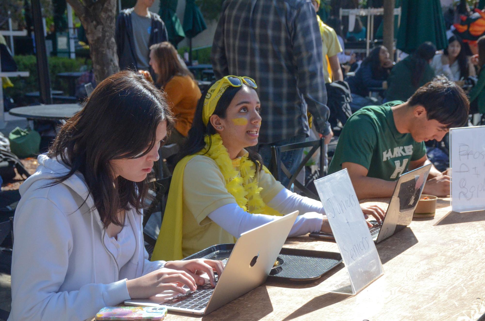 Margot Grignou (9), Megha Unny (11) and Brady Tse (12) check in students dressed in their class colors. Today’s Spirit Week theme, class colors, featured freshmen in white, sophomores in black, juniors in yellow and seniors in green.
