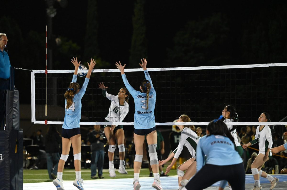 Opposite Hitter Ruhi Banerjee (12) attempts a hit against two Branham Blockers. The Eagles triumphed 25-15 in the fourth set.
