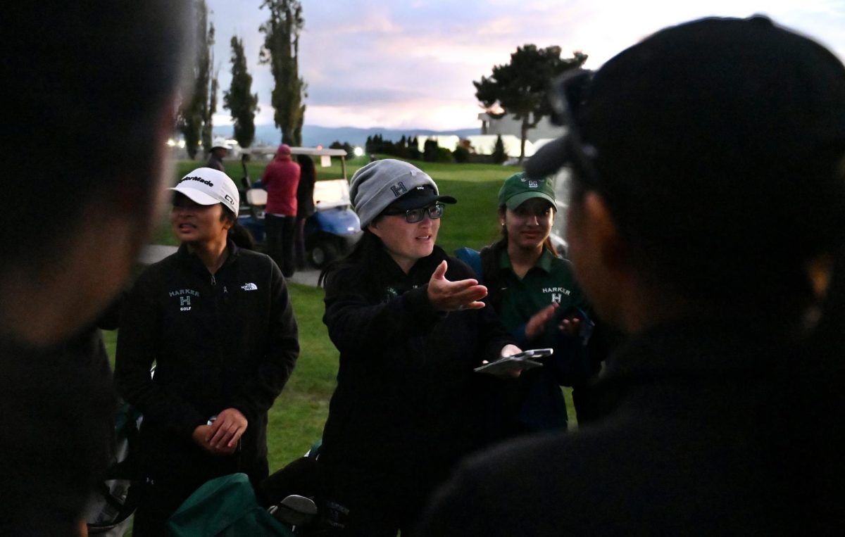 Varsity girls golf coach Ie-Chen Cheng talks to the team post-match. She went over strategies on how to improve, like focusing more mentally and not making risky decisions.