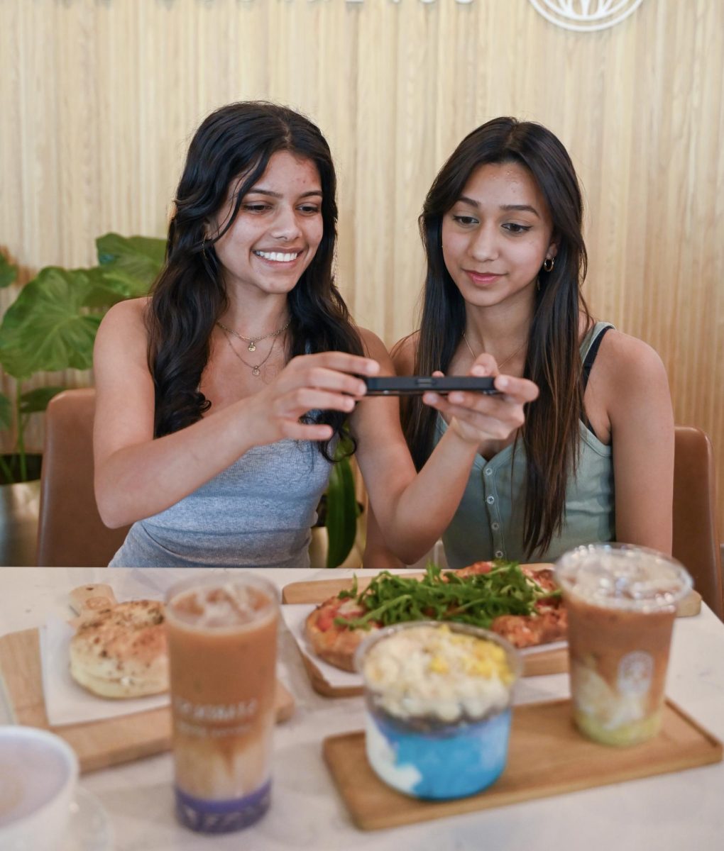 Seniors Tanvi Sivakumar and Angelina Antony take a photo of their food before digging in. Nowadays, the need for digital presence has shifted experiences from living in the moment to curating life.