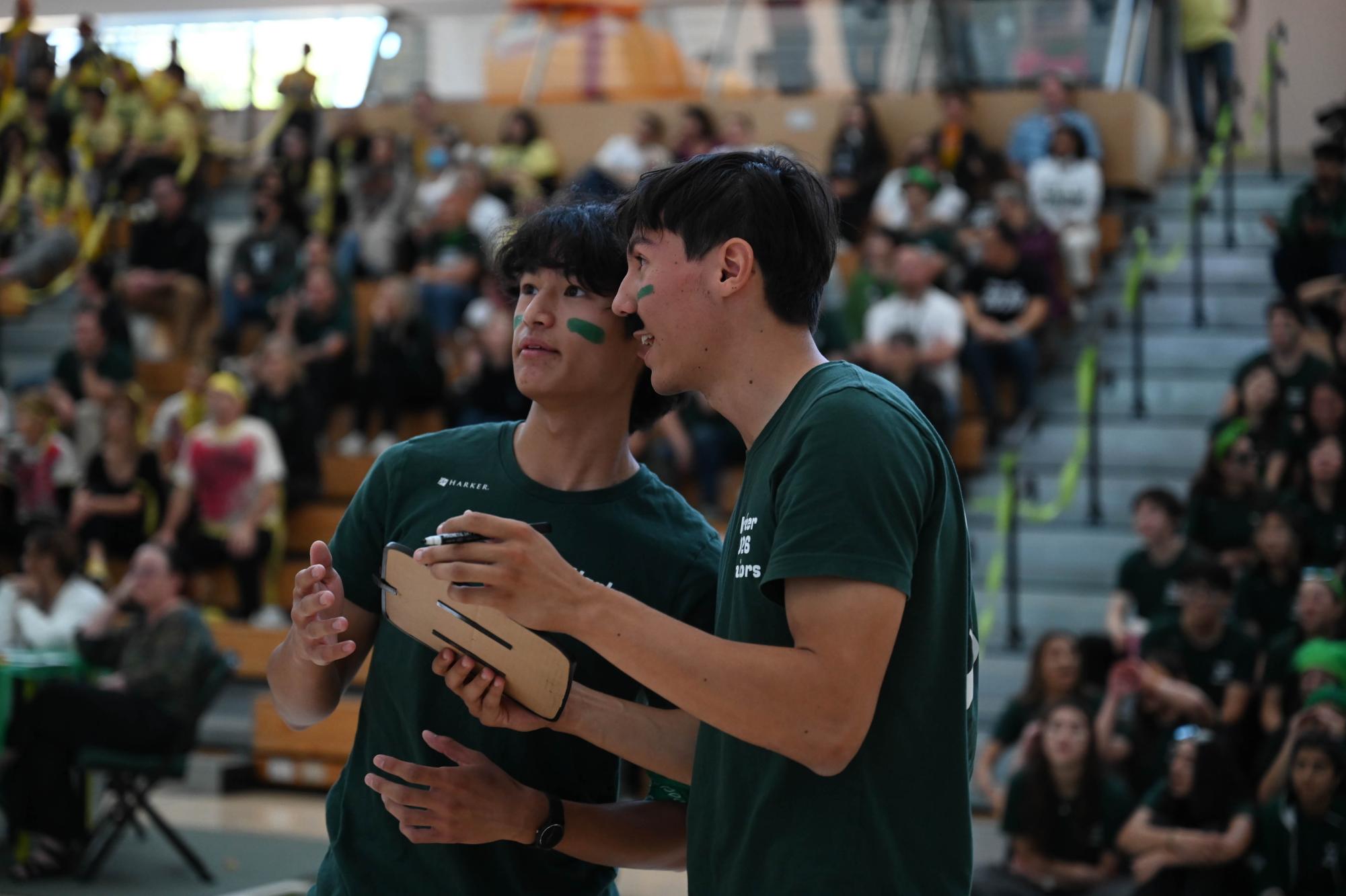 Seniors Spencer Chang and Brady Tse discuss their answer during a relay game. Elected representatives, with the help of their class, had to identify teachers from close-up photos of specific facial features.
