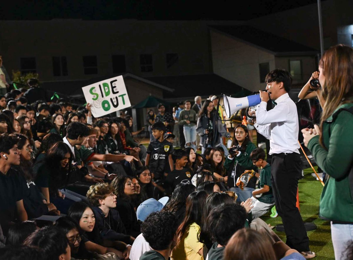 Senior Luke Wu encourages audience members to cheer for the team. He led them in the A-C-E cheer.