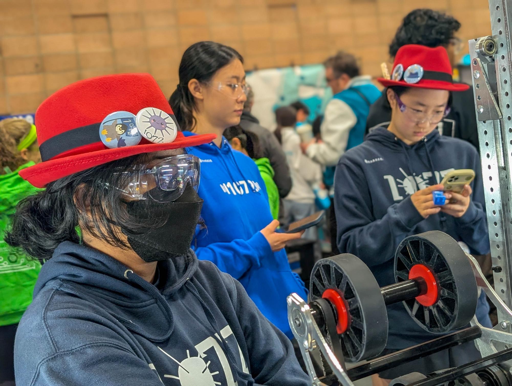 Design Co-Director Chetana Pramanik (11) assesses the condition of the team's robot between matches. Regular maintenance helps prevent hardware failures.
