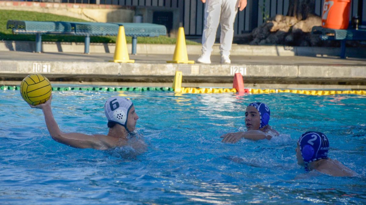 Junior Ian Cheline winds back for a shot at the goal, guarded by two players from Los Altos. He scored to bring the score to 8-6.