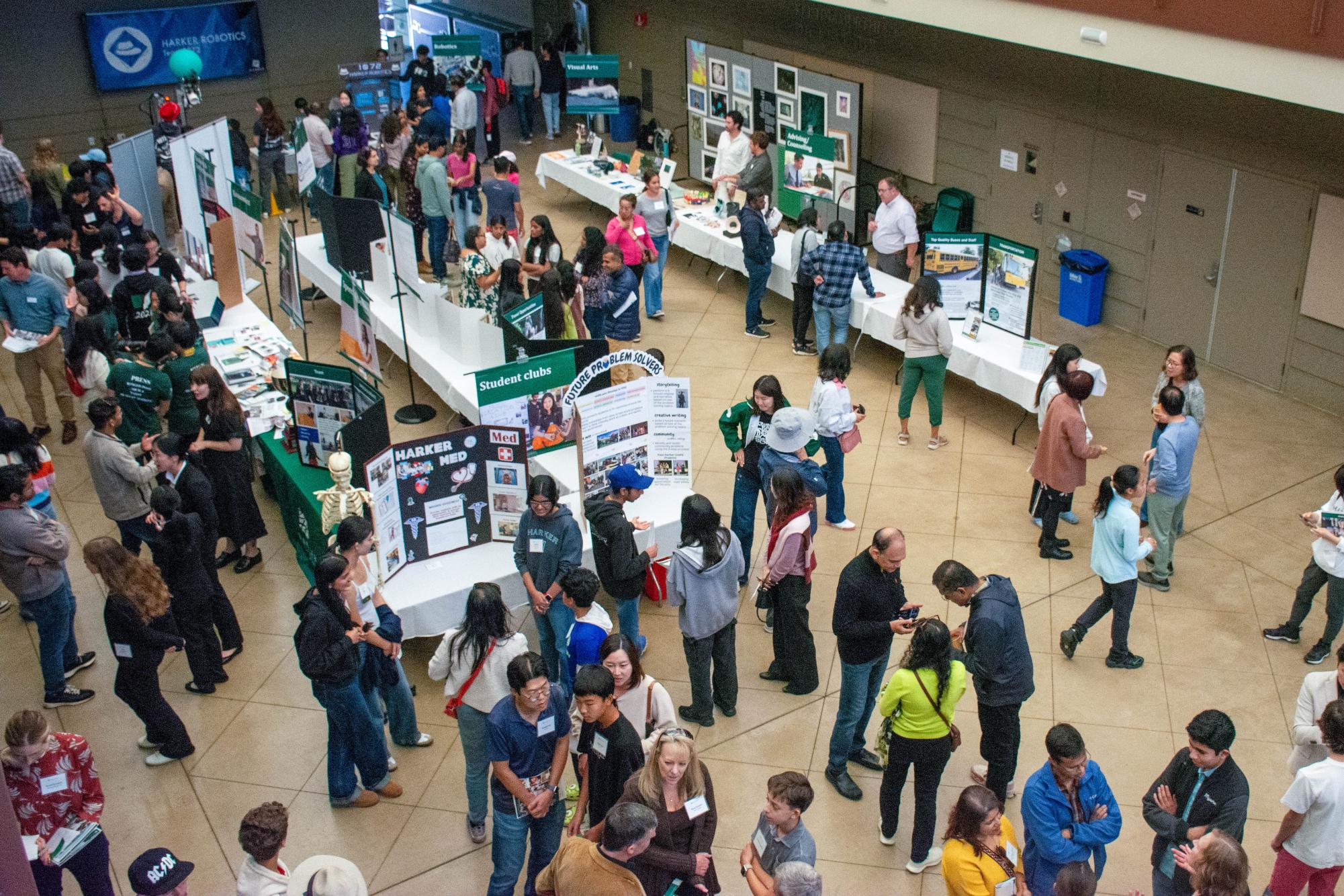 Attendees mingle with student and faculty representatives. In addition to every academic department, programs including Robotics, Counseling and Speech & Debate had booths.