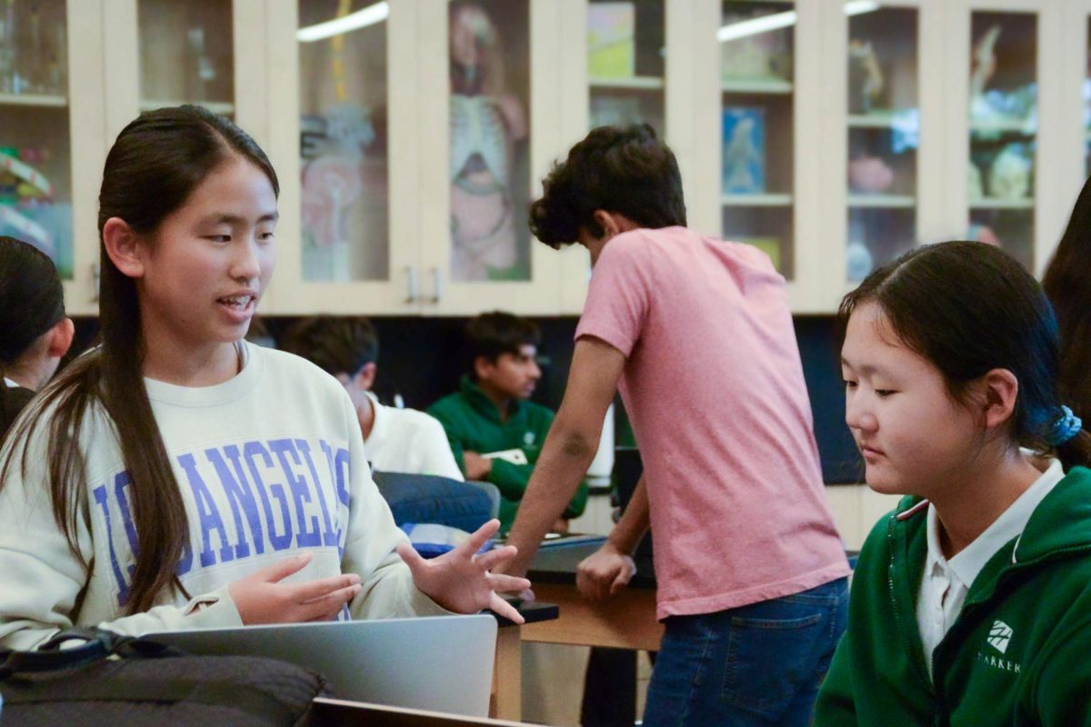 A former member of the SRP program, frosh Hannah Tay advises an eighth grader on proposal writing. During the workshop, Research Club members walked around the room learning about and assisting the students with their science research projects.