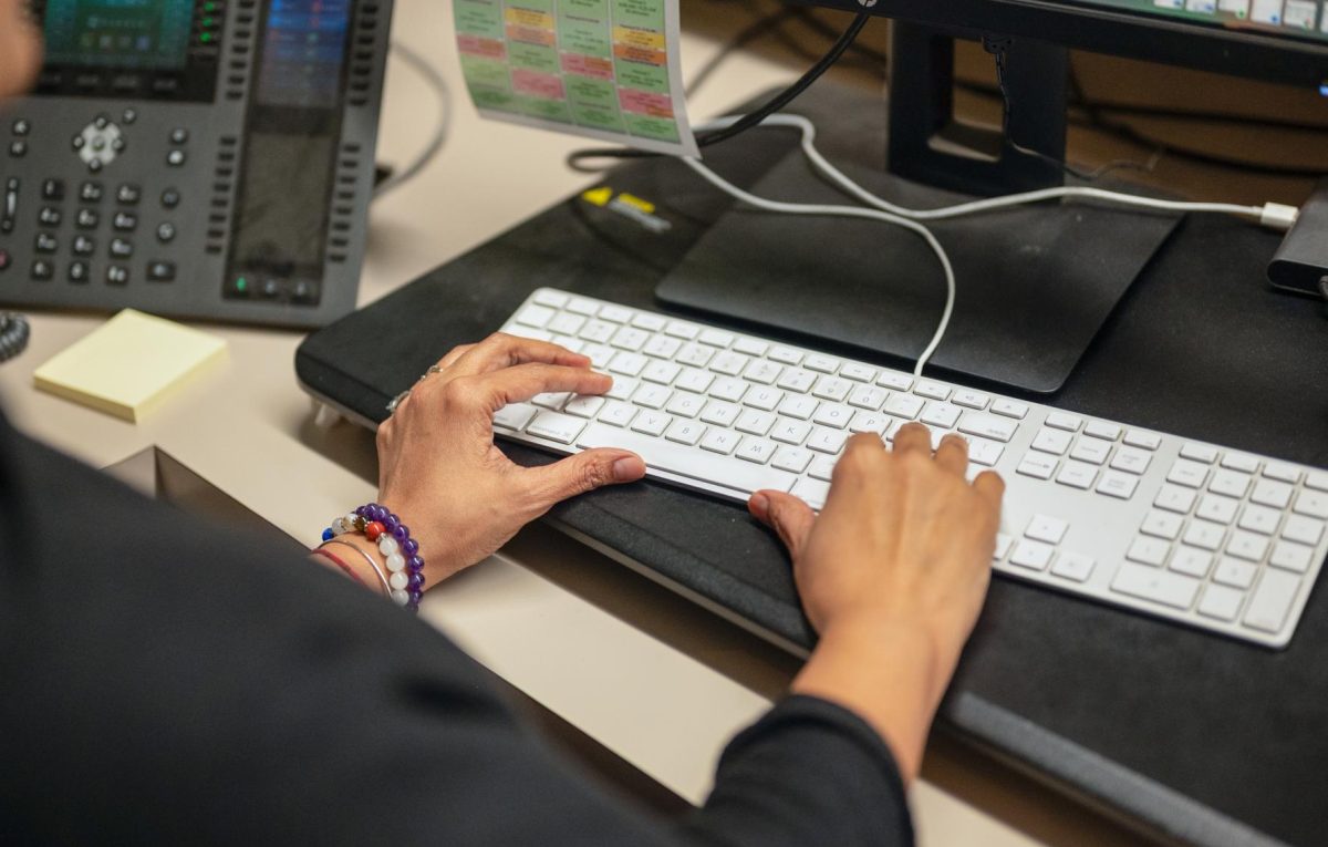 Attendance Coordinator Rietu A. Raaj types on her computer keyboard. Along with her role at Harker, Raaj is a certified resilience coach for young adults and high school students.