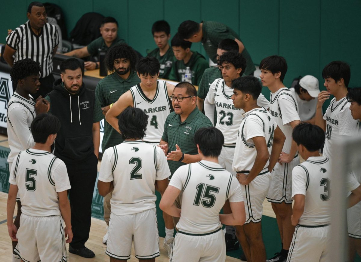 Head Coach Alfredo Alves discusses strategy during a timeout in the fourth quarter. He pushed the team to focus on efficient shot selection.