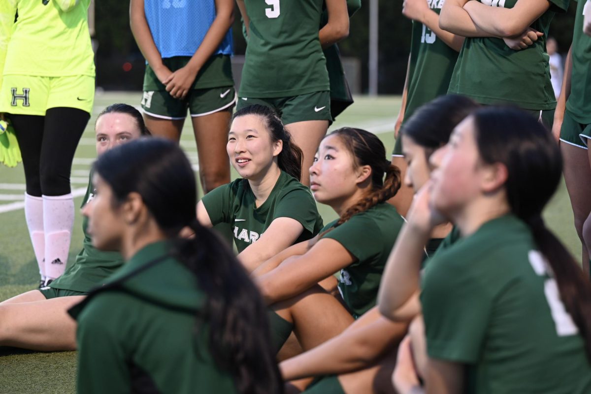 Center back Audrey Yang (12) smiles as she listens to assistant coach Jorge Chen during halftime. Audrey played a key role in defense during the first half and moved to play in the midfielder position during the last few minutes of the second half.