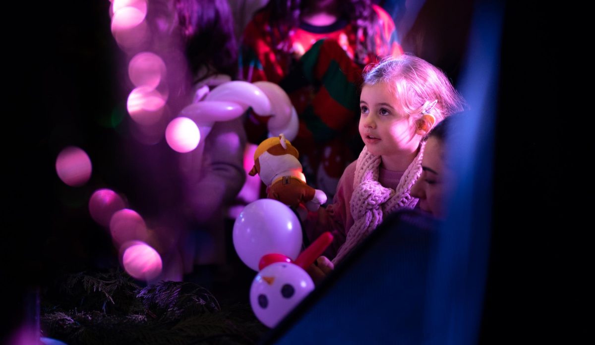 A child gazes at Downbeat and Capriccio as they sing a variation of "Deck the Halls." The variation began in a traditional, four-part arrangement of the carol, but quickly morphed into a jazzy, belty style.