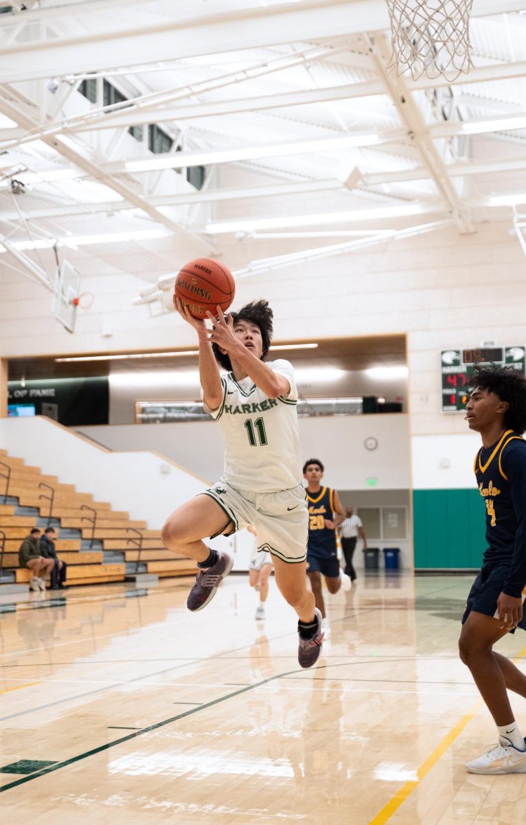 Guard Robinson Xiang (12) contorts in the air to finish the layup after being fouled moments prior. Robinson shot 40% from the field and also notched two assists, two steals and two rebounds.