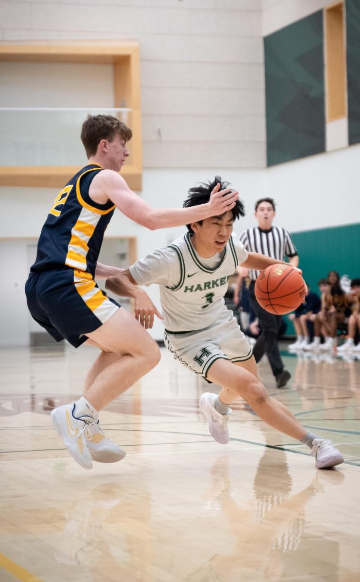 Point guard Caden Ruan (12) drives hard to the basket and draws a foul. Harker's offense centered around a guard driving to the basket, drawing attention from multiple defenders, and kicking it out to an open teammate.