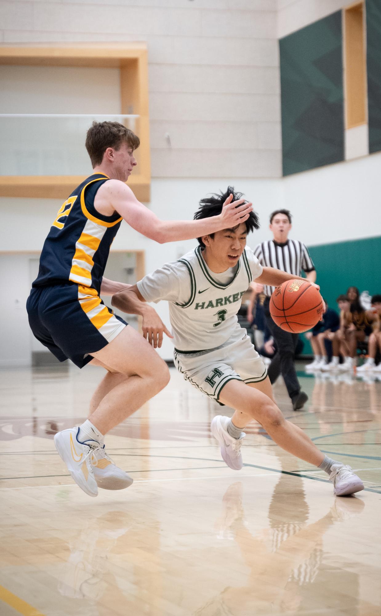 Point guard Caden Ruan (12) drives hard to the basket and draws a foul. Harker's offense centered around a guard driving to the basket, drawing attention from multiple defenders, and kicking it out to an open teammate.