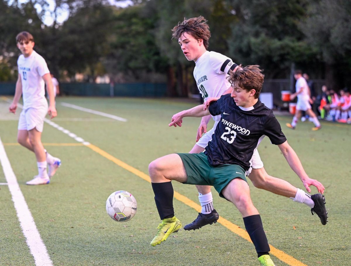 Central attacking midfielder Ryder Hewitt (12) battles a Pinewood player for the ball as forward Vova Shchegrov (11) looks on. "It was a pretty dirty match," winger Stanley Chen (12) said. "We didn't play our best, but we came out with a win."