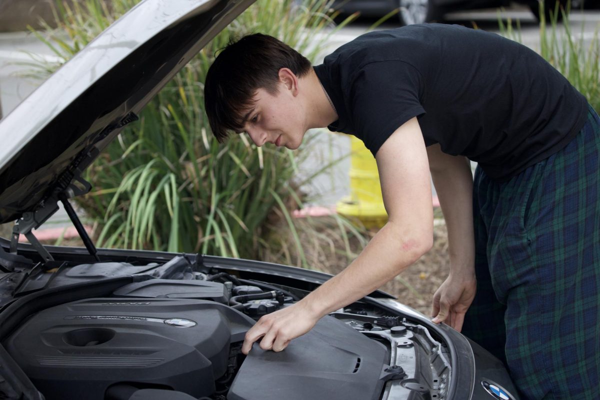 Vova Shchegrov (11) inspects his car engine before driving. Through his work as a mechanic, Vova gained hands-on engineering skills and a deeper understanding of how cars function.