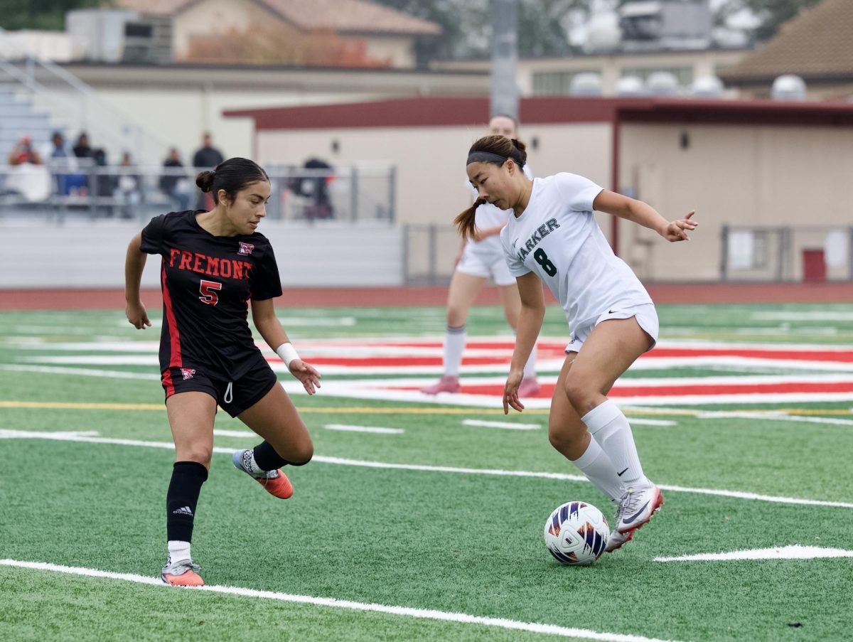 Varsity girls soccer midfielder Eva Cheng (12) faces off against a Fremont defender. Eva led the team offensively to WBAL playoffs.