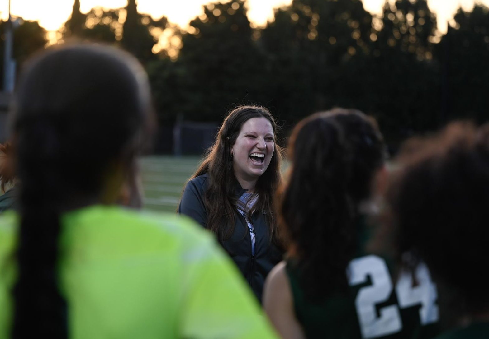 Head coach Taylor Ortiz laughs as she debriefs with the team during half time. She encouraged the team to continue going for the ball.