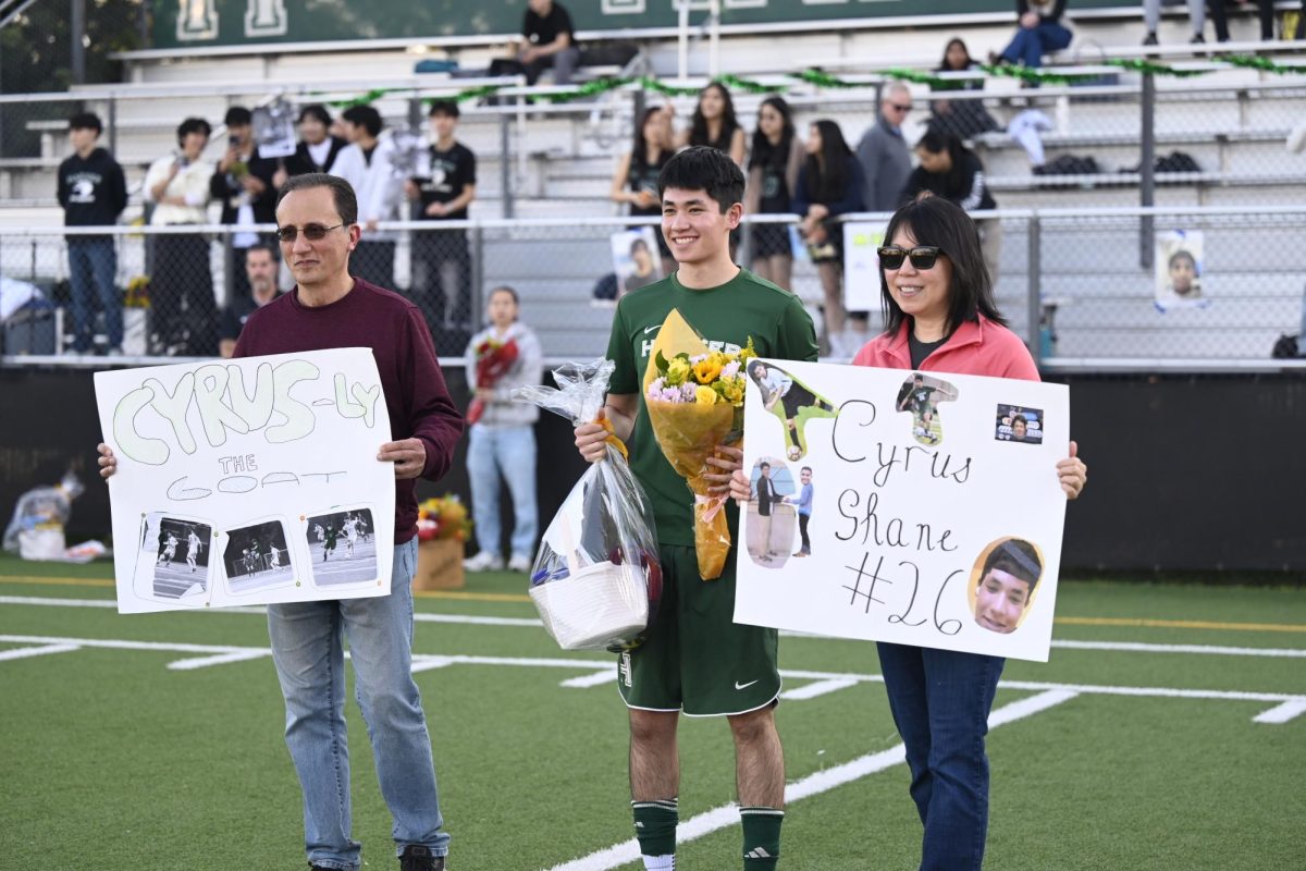 Forward Cyrus Ghane (12) smiles as he poses for a photo with his family members. He kicked off the game and was subbed out after because of his injury.