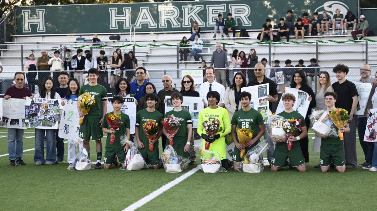 Varsity boys soccer seniors pose for a photo after the senior ceremony. Each senior was honored with flowers and posters designed by the rest of the team.
