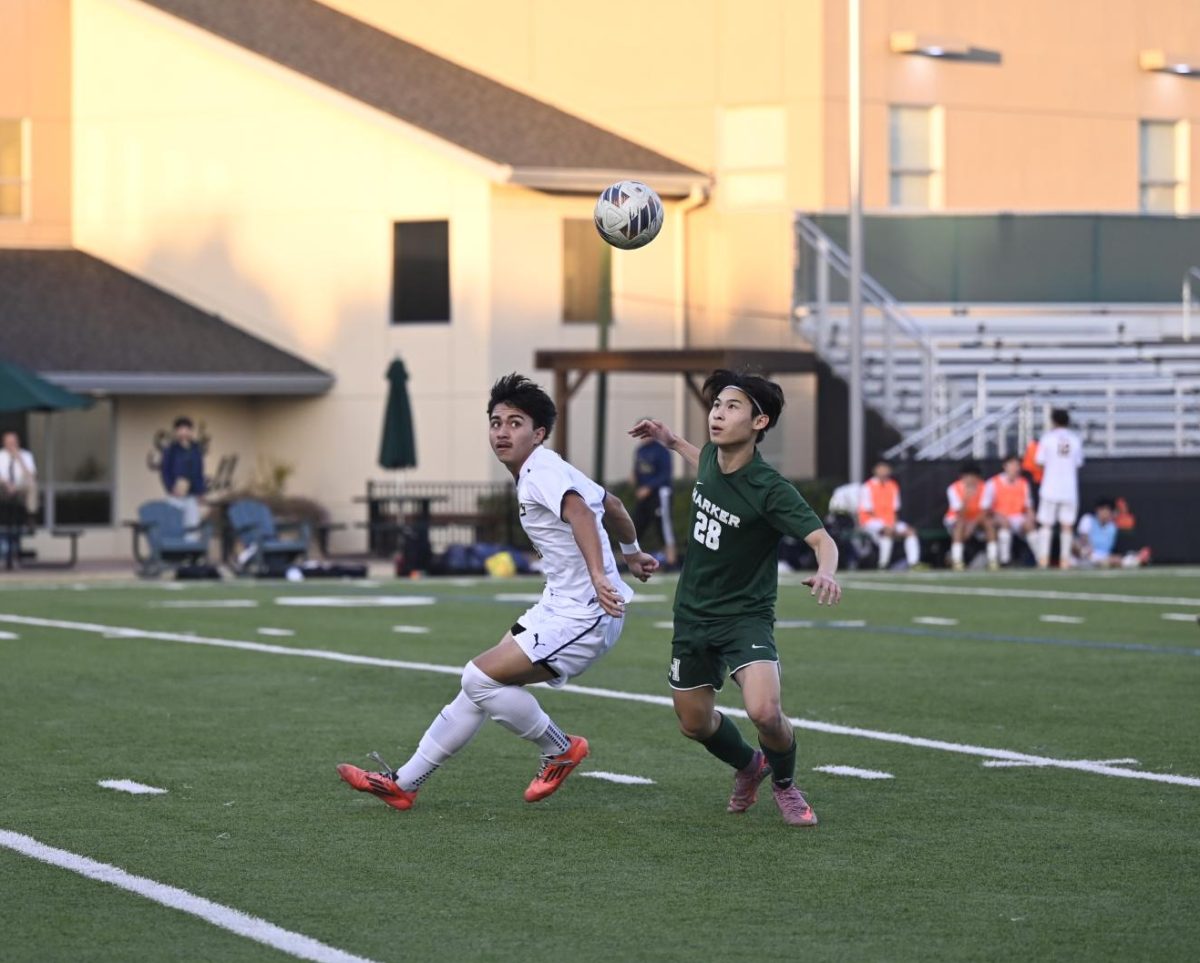 Forward Stanley Chen (12) looks up at the ball after the King's goalie punted it. Stanley contributed offensively, driving ahead of King's defenders towards the goal.