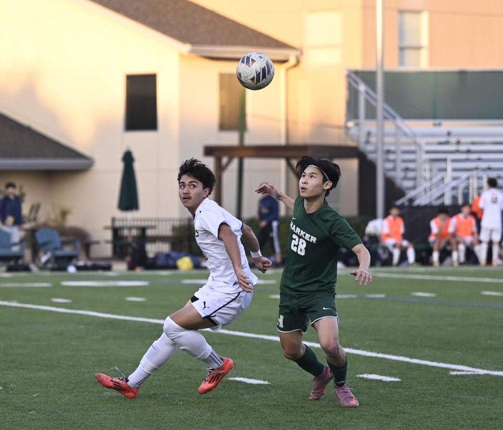 Forward Stanley Chen (12) looks up at the ball after the King's goalie punted it. Stanley contributed offensively, driving ahead of King's defenders towards the goal.