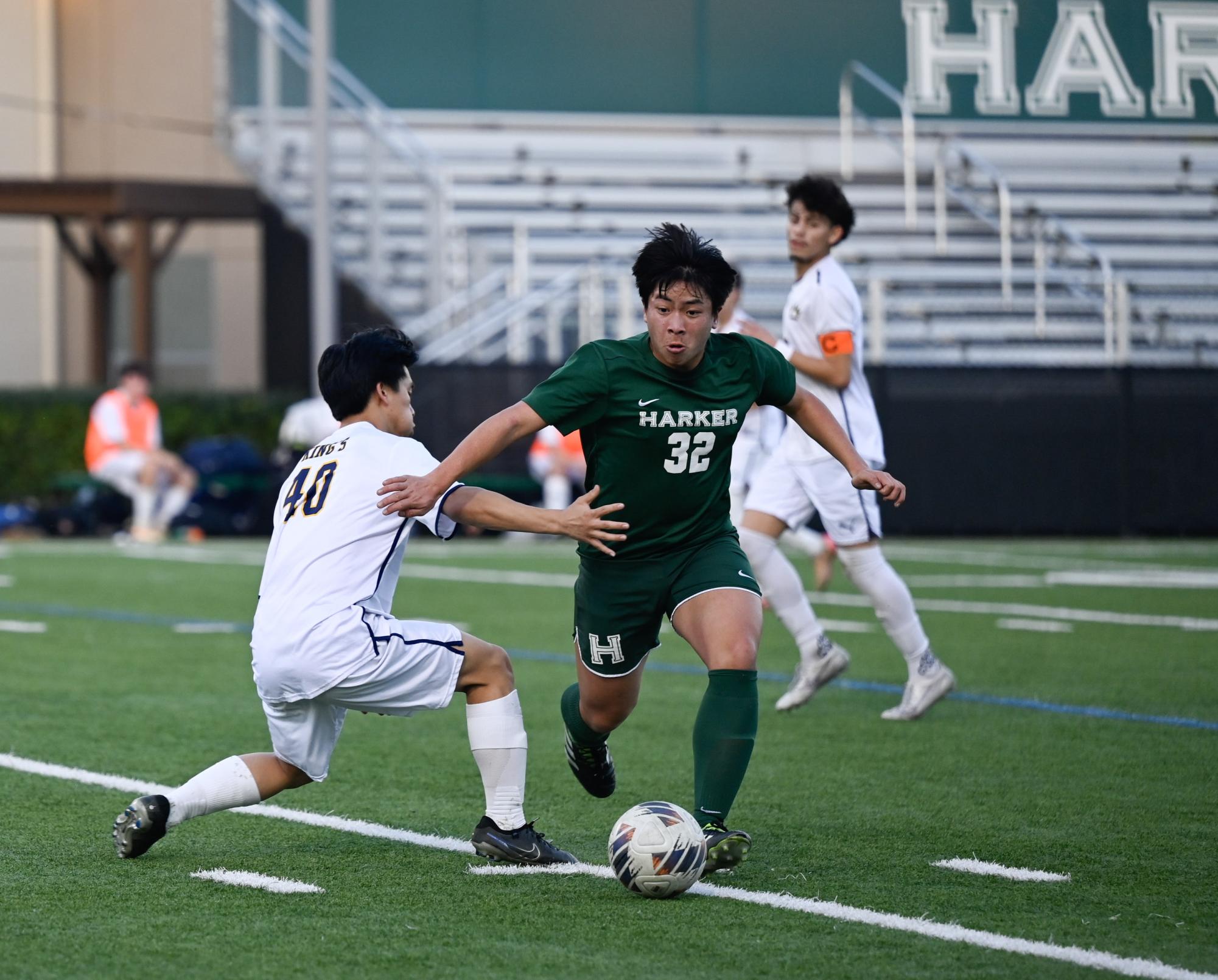 Midfielder Sam Li (11) shoulders past a King's defender. He worked with midfielder Ryder Hewitt (11) to push possession of the ball away from Harker's side.