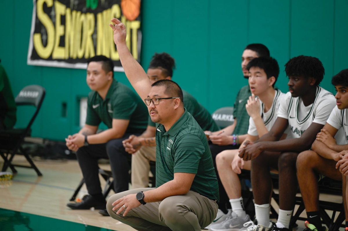 Head coach Alfredo Alves signals a play. In practice, Alves coached the team in facing 1-3-1 zone, which Eastside's defense implemented.