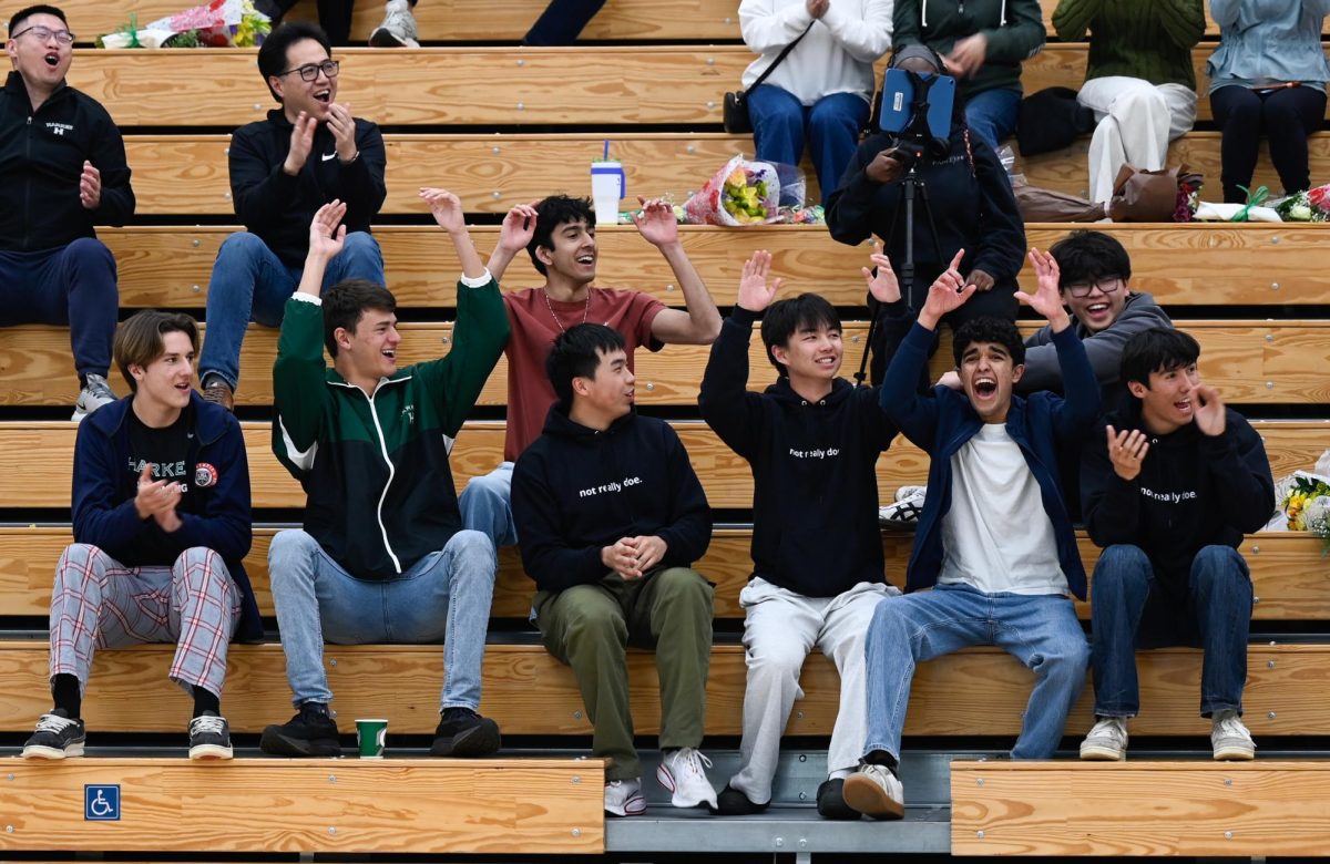 Audience members cheer for the varsity boys basketball team during senior night. The team devised multiple trick plays during the game, with guard Rishaan Thoppay (12) scoring off of one such play.
