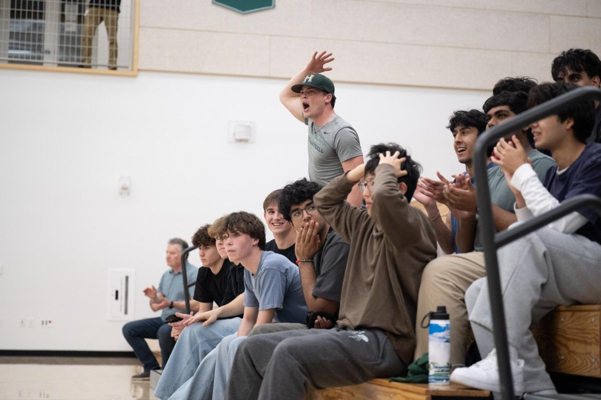 Audience member Jackson Powell (12) reacts to a kill by opposite hitter Aydin Mesic (10). Cheers from the audience members helped the team regain their energy during the third and fourth sets.