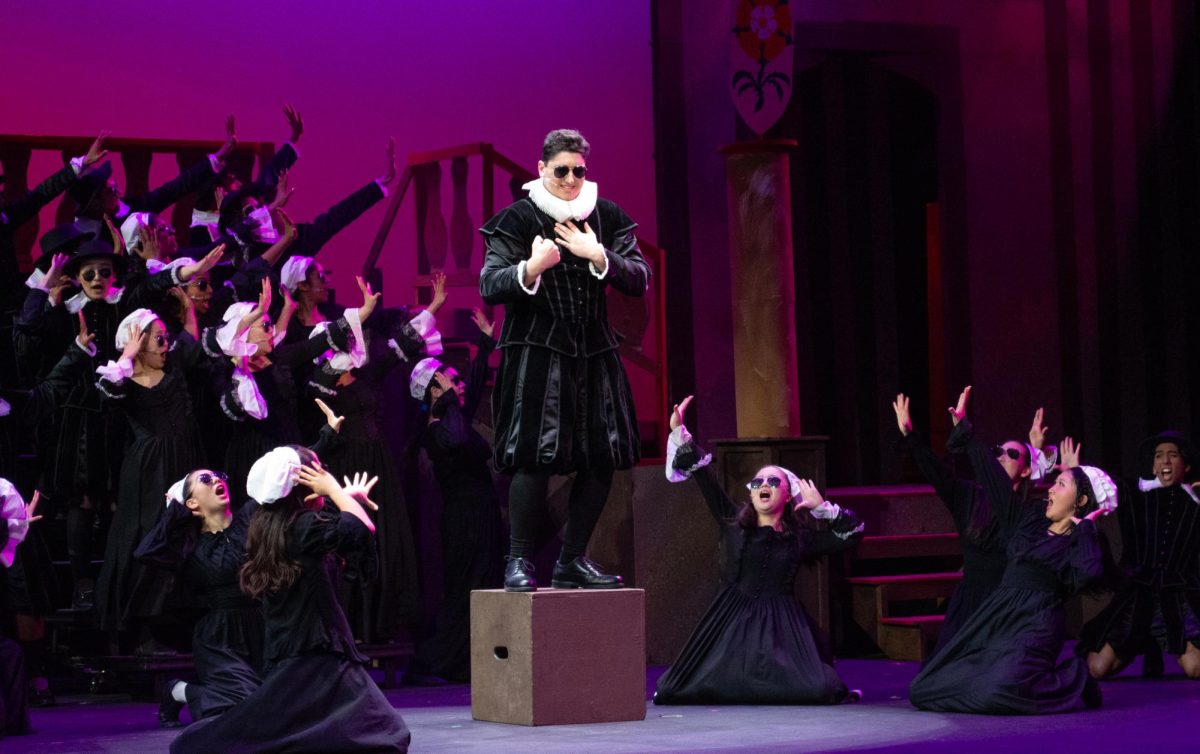 Henry Fradin (12), playing Brother Jeremiah, passionately sings while being surrounded by his Puritan supporters. Brother Jeremiah was also the father of Portia, the love interest of Nigel Bottom, one of the main two brothers in the musical.