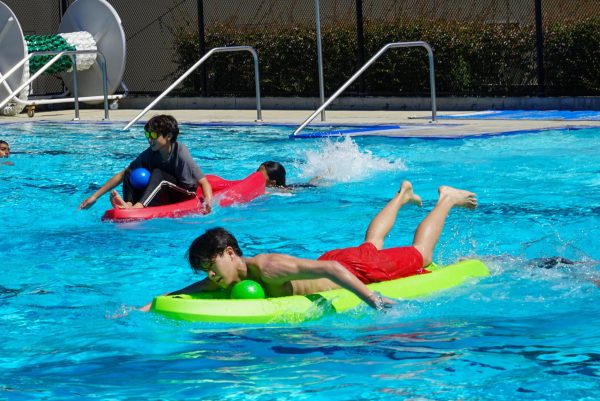 Senior Timmy Chen and Frosh Jordan Sun paddle their kayaks towards the finish line. The seniors took second place while the frosh finished last in the event.