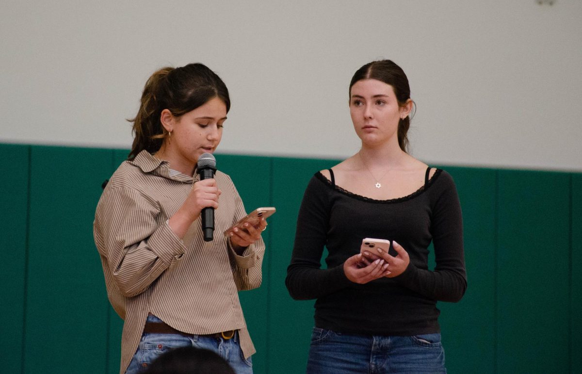 Jewish Affinity Group co-presidents Abigail Sachse (11) and Shaina Cohen (12) speak at a school meeting about Holocaust Remembrance Week. They explained that in Hebrew, they use the word "zachor" to express remembrance.