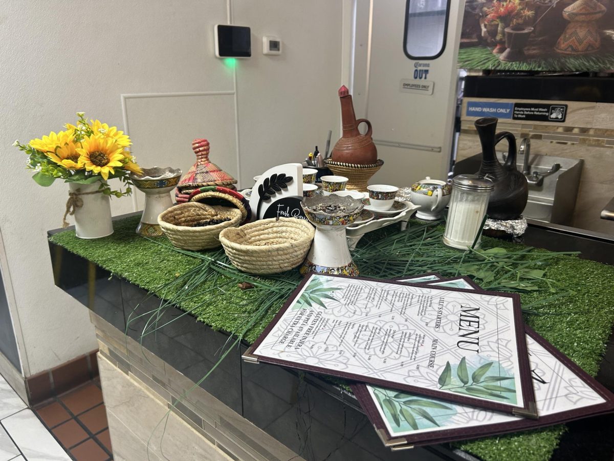 A traditional Ethiopian coffee set is displayed on the counter. Equipment often includes clay pots, small, intricately decorated cups and fresh coffee beans.