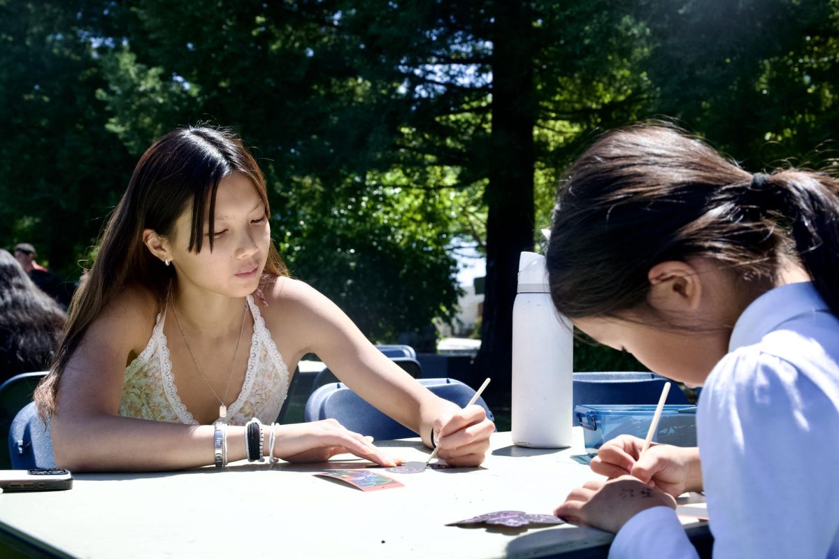 Senior Linda Zeng works on scratch art with her younger Eagle Buddy. Other art-related activities included making lanyards and decorating coloring pages.