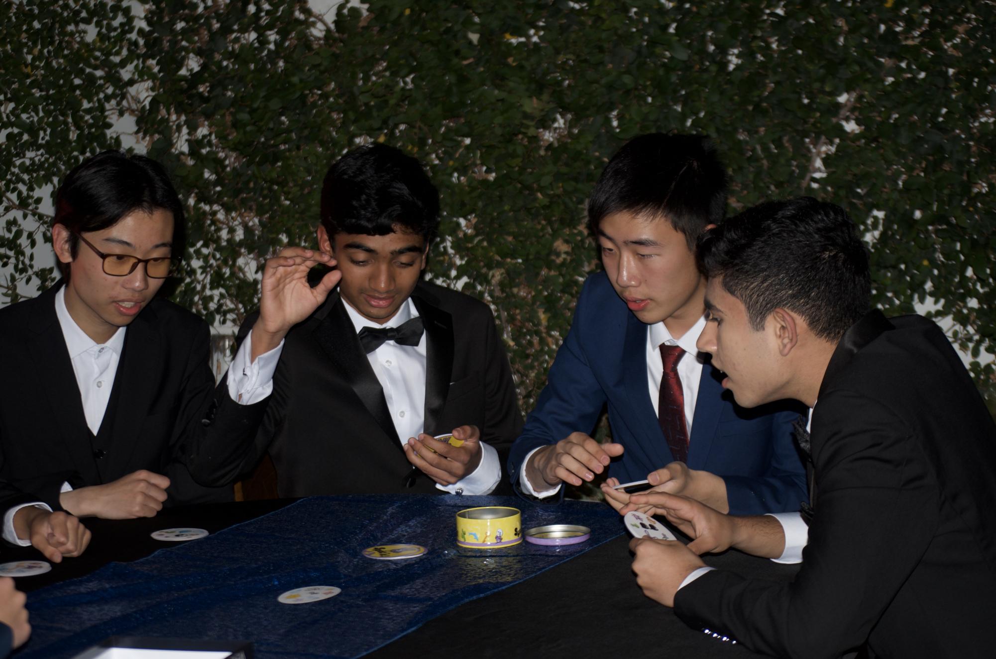 Juniors Leon Le, Sanjith Senthil, Kevin He and Senior Ishan Mysore play a board game. Students could engage in a wide range of activities throughout the night, including a photo booth, a roulette game and a claw machine.