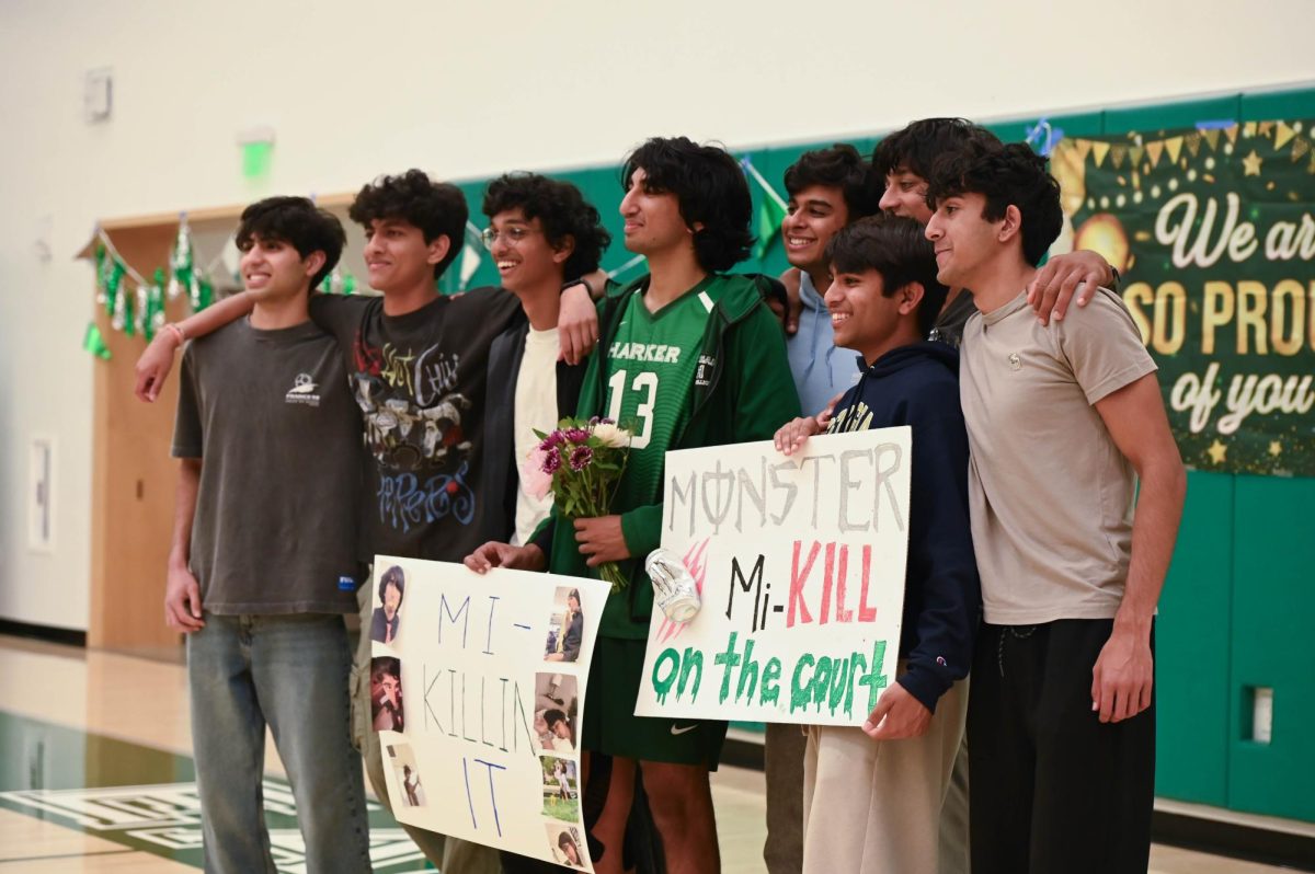 Senior Mikhil Kiran poses with his friends for a photo holding senior posters. Harker defeated Lynbrook in three sets during their senior night.