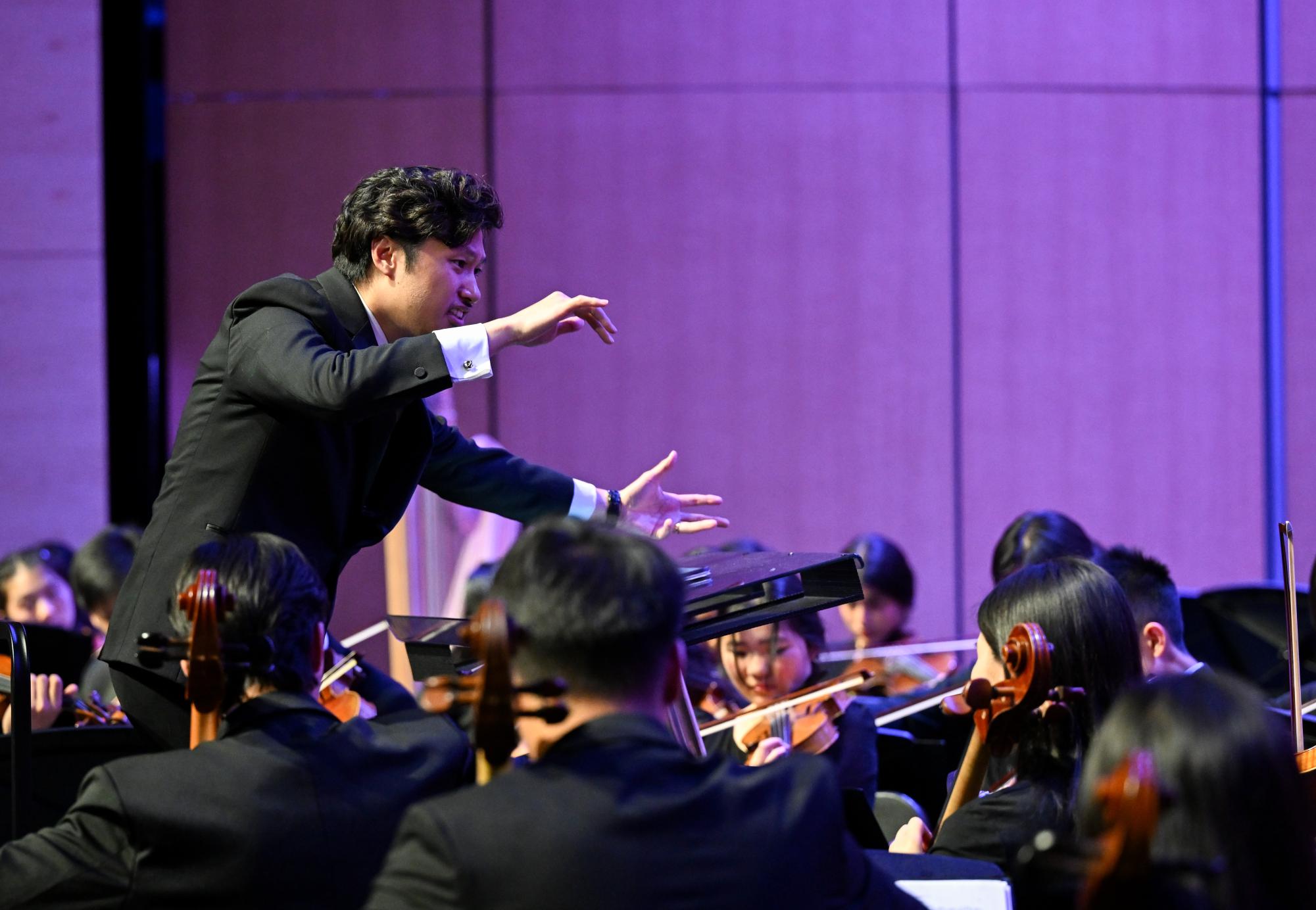 Orchestra director Jaco Wong conducts during Tchaikovsky's Violin Concerto in D Major. Wong congratulated and gave a short speech about each of the seniors at the end of the concert.