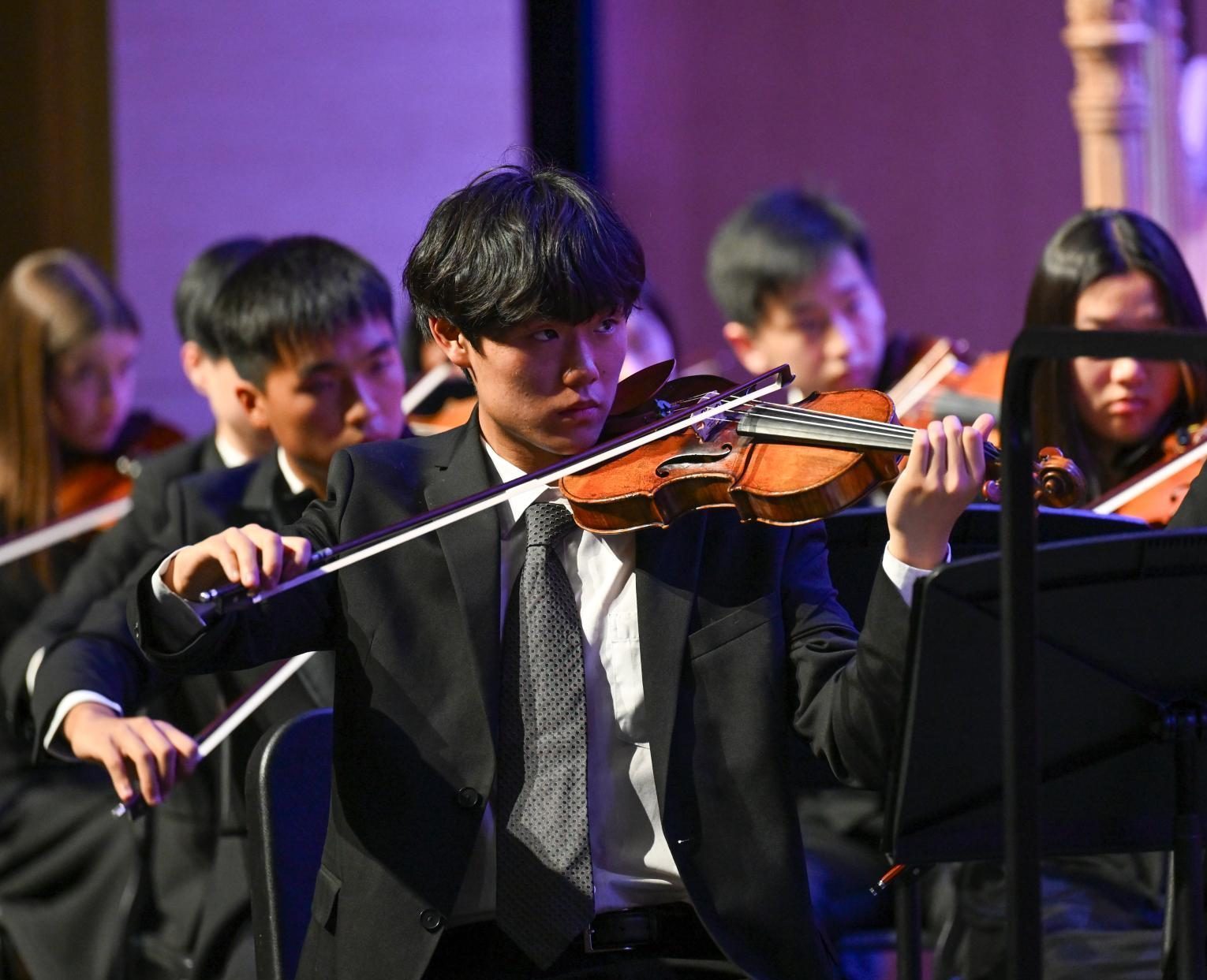 Violinist Hanz Baek (11) draws his bow across the strings as he plays Holst's "Jupiter." The piece is a part of a seven-movement suite called "The Planets."