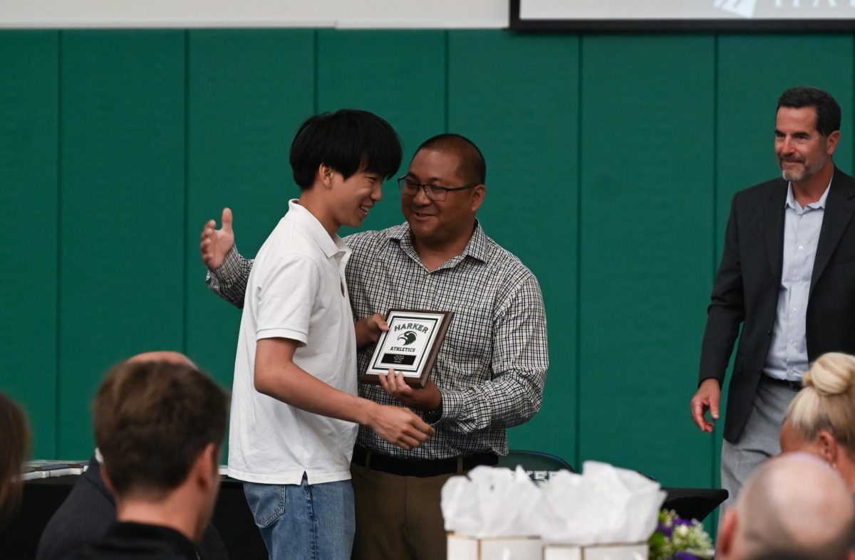 Assistant Athletic Director Alfredo Alvez awards senior Caden Ruan with the boys basketball Eagle Award. Each coach presented one or two students from each team with the Eagle award, which rewards work ethic, leadership, and teamwork.