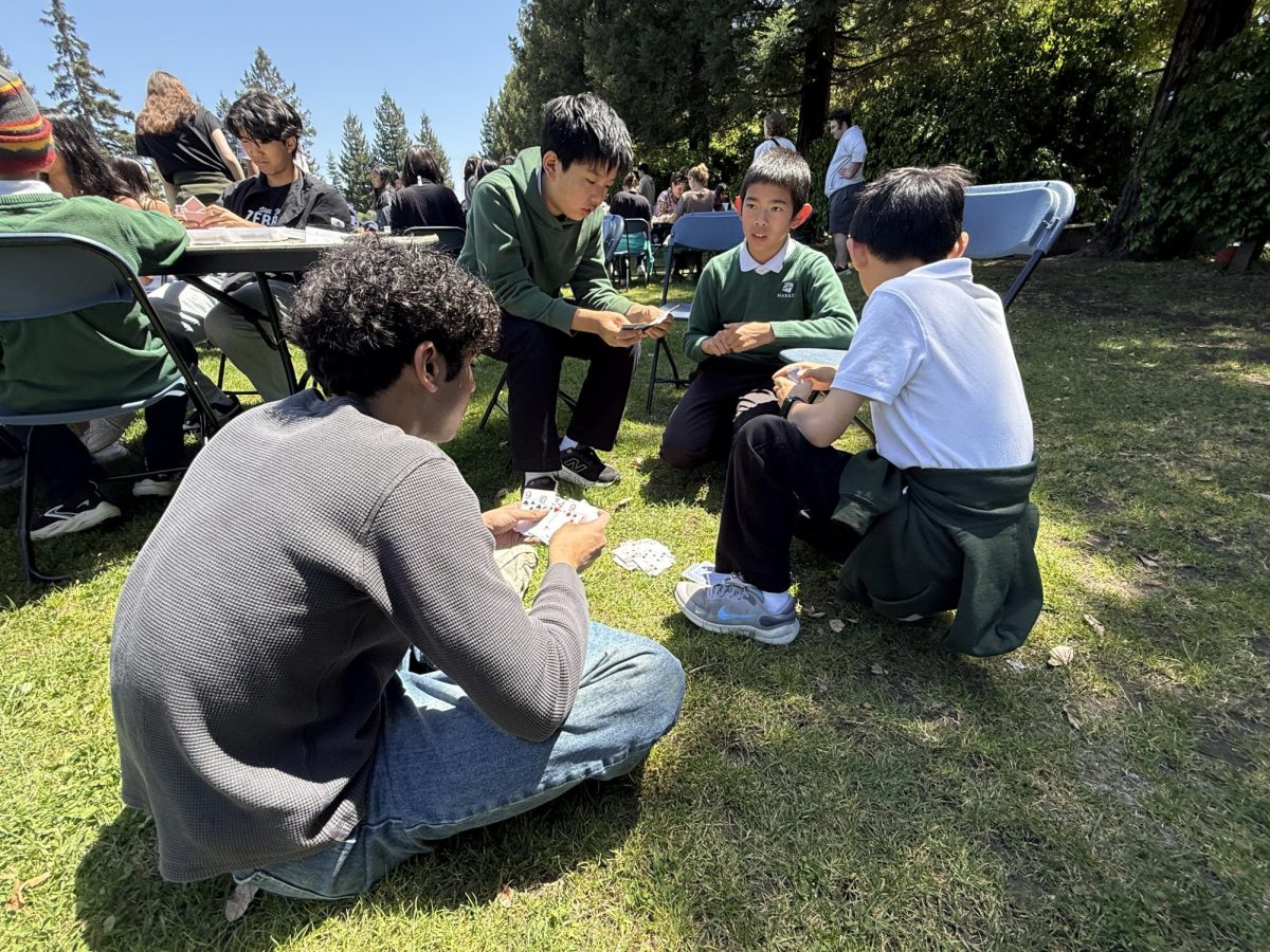 Senior Avi Bahri plays cards with his eagle buddy group. The seniors met with the fifth graders at the lower school for their final eagle buddy meet up.