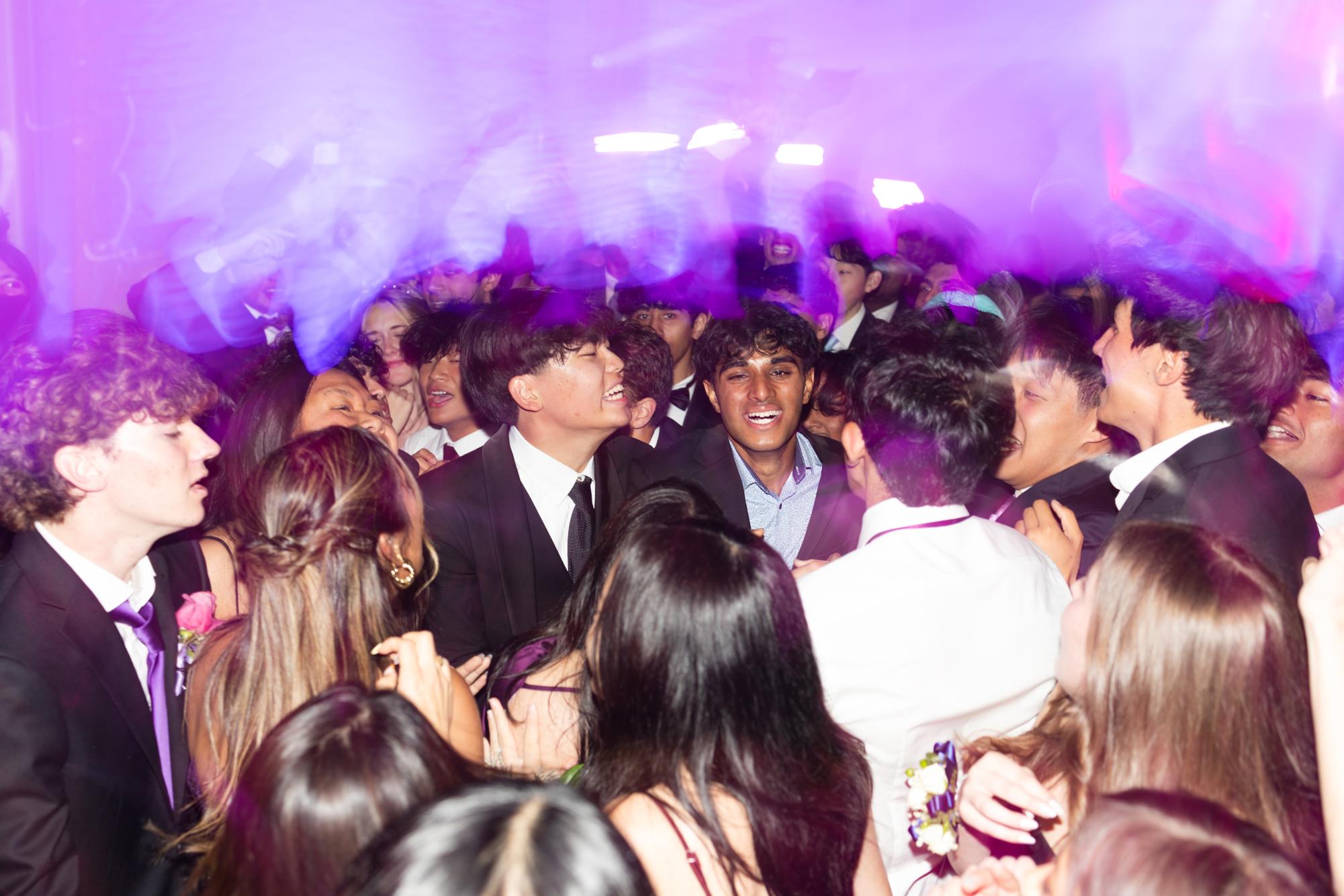 Seniors Lucas Chen and Vivek Yella dance with their friends. The dance floor incorporated visual effects like lasers and a disco ball.