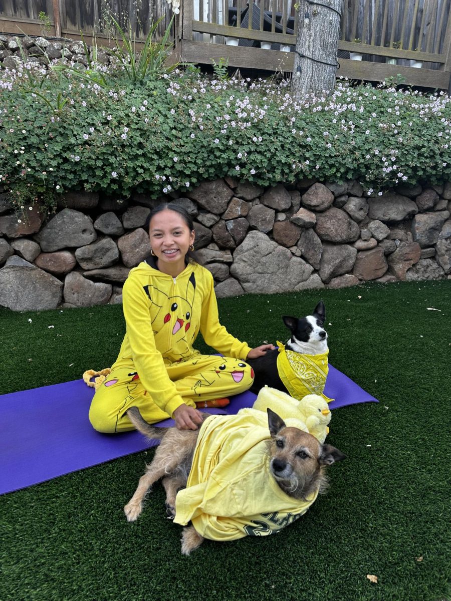 Junior Ava Alvarez smiles with her dogs, sharing matching outfits with them. When she first became a dog owner during COVID, she relied on them for socialization and emotional relief.