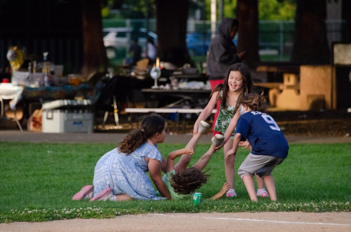 Children play near the baseball field in Washington Park. The area, although intended for baseball, is also used for parties and other community events.